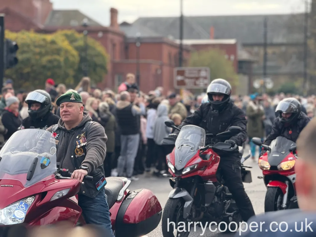 A motorcyclist wearing a green beret leads others in the Remembrance Day procession.